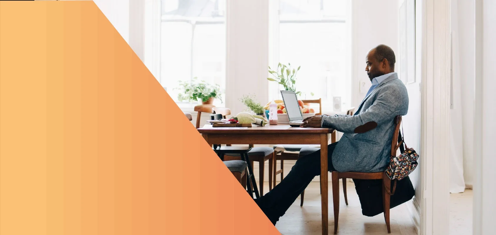 Man working on a laptop in his dining room.